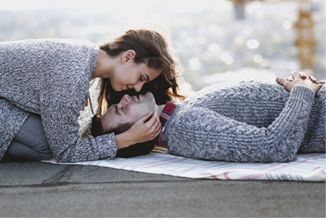 זוג שוכב על סמיכה ומפגין זוגיות משגשגת